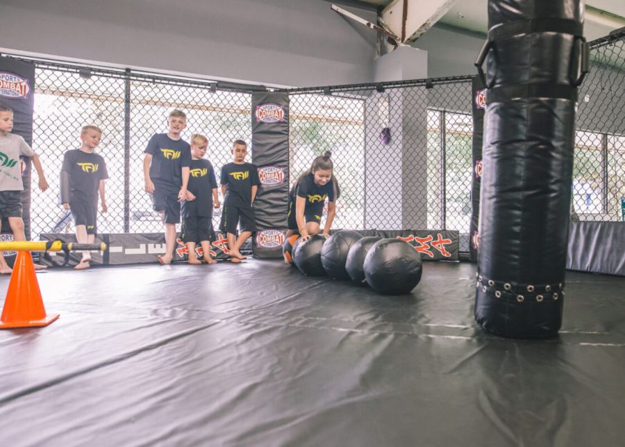 Kids participating in martial arts and kickboxing classes at Train Fight Win gym in Tallahassee during the Spartan Kids Program.